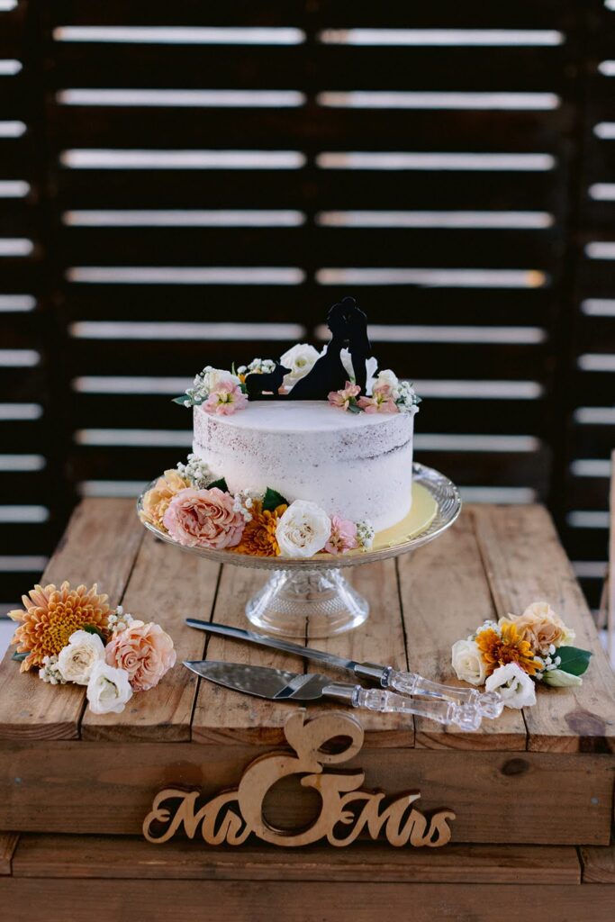 A wedding cake with pink and orange flowers.