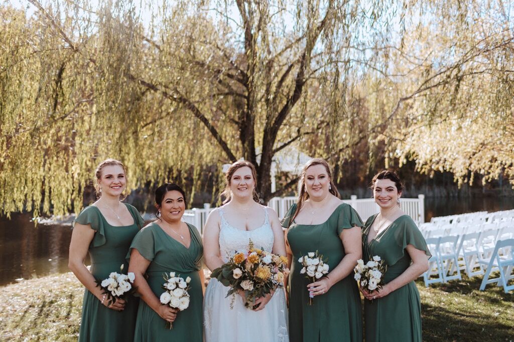 A bride and two bridesmaids hold bouquets.