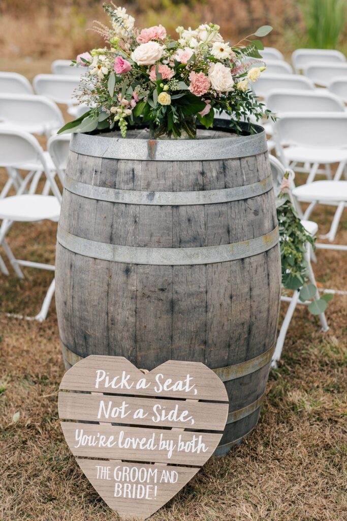 A floral arrangement by One Last Avocado sits on top of a wine barrel for a wedding at Silver Fox Lavender Farm.