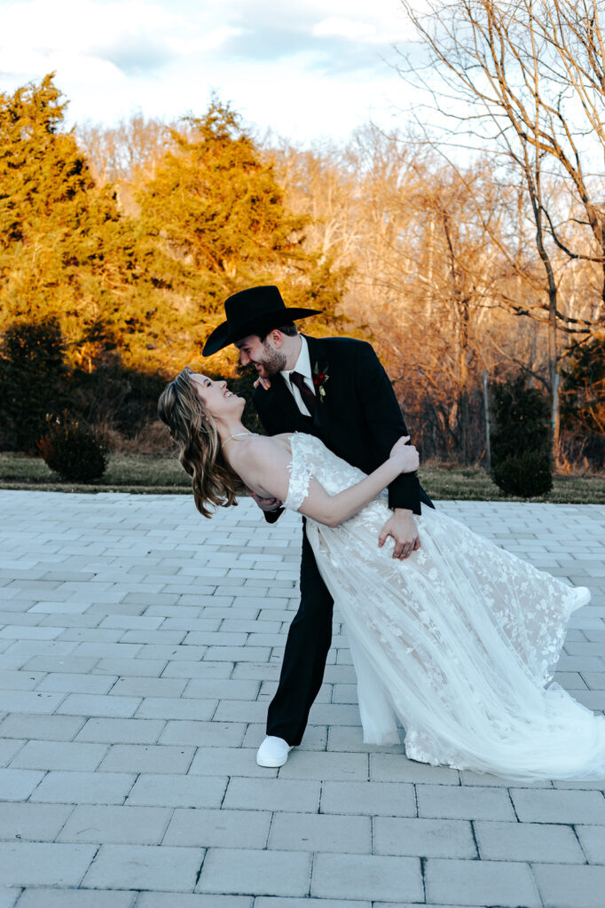 A groom dips his bride during a virginia wedding. Wedding venue: 48 Fields Farm. Florist: One Last Avocado Floral Design