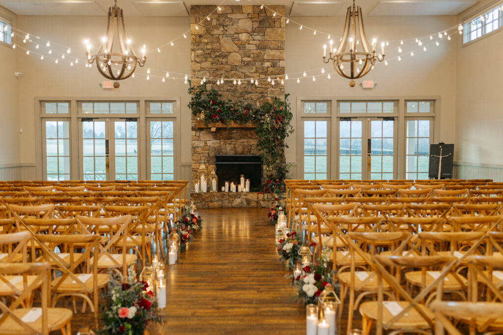 Garden-style fireplace flowers with layered greenery and colorful winter blooms and candles at King Family Vineyards wedding