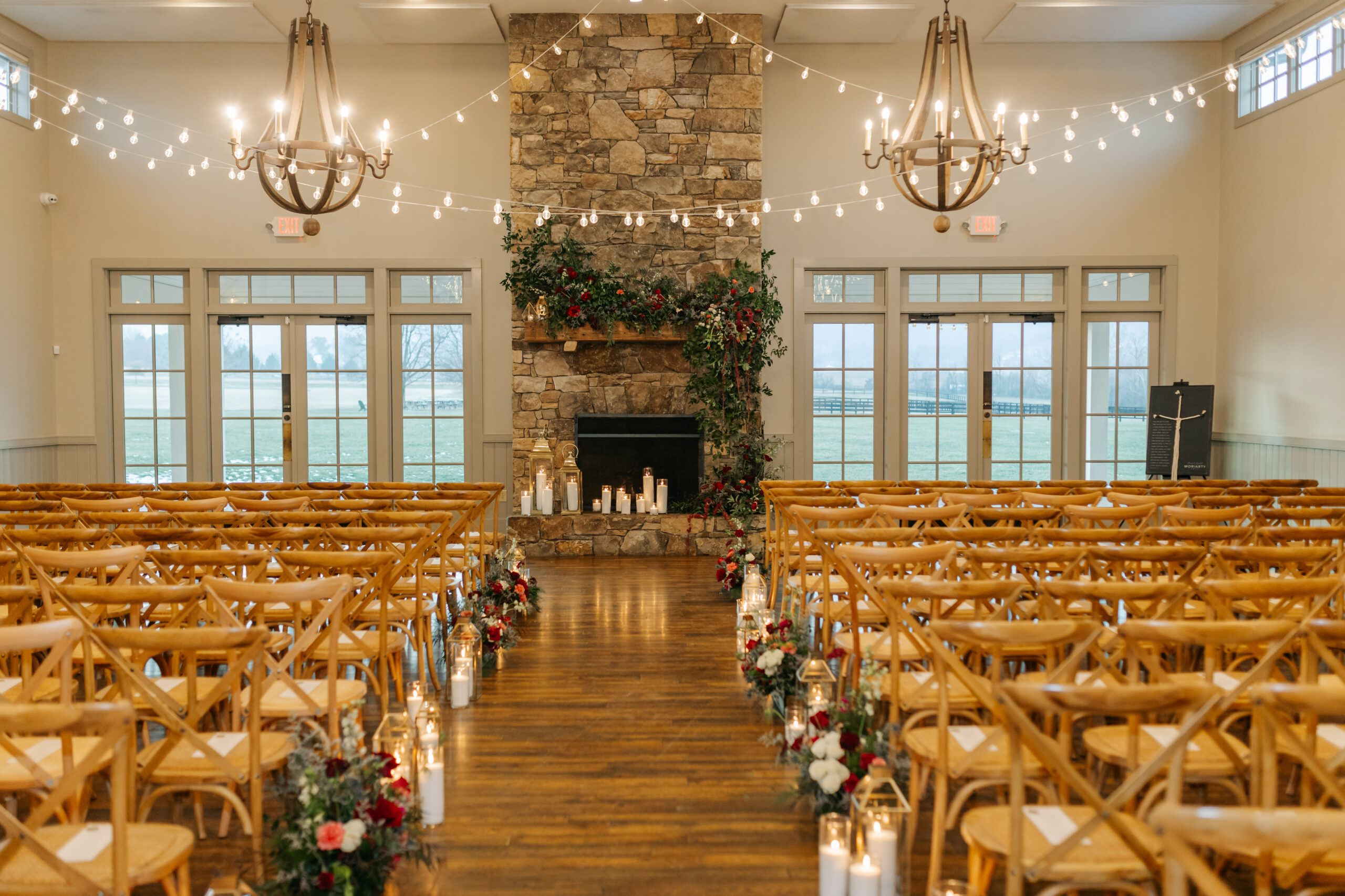 Garden-style fireplace flowers with layered greenery and colorful winter blooms and candles at King Family Vineyards wedding