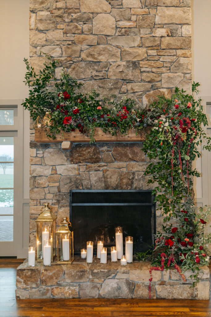 Garden-inspired floral installation framing fireplace at cozy indoor Virginia winter wedding