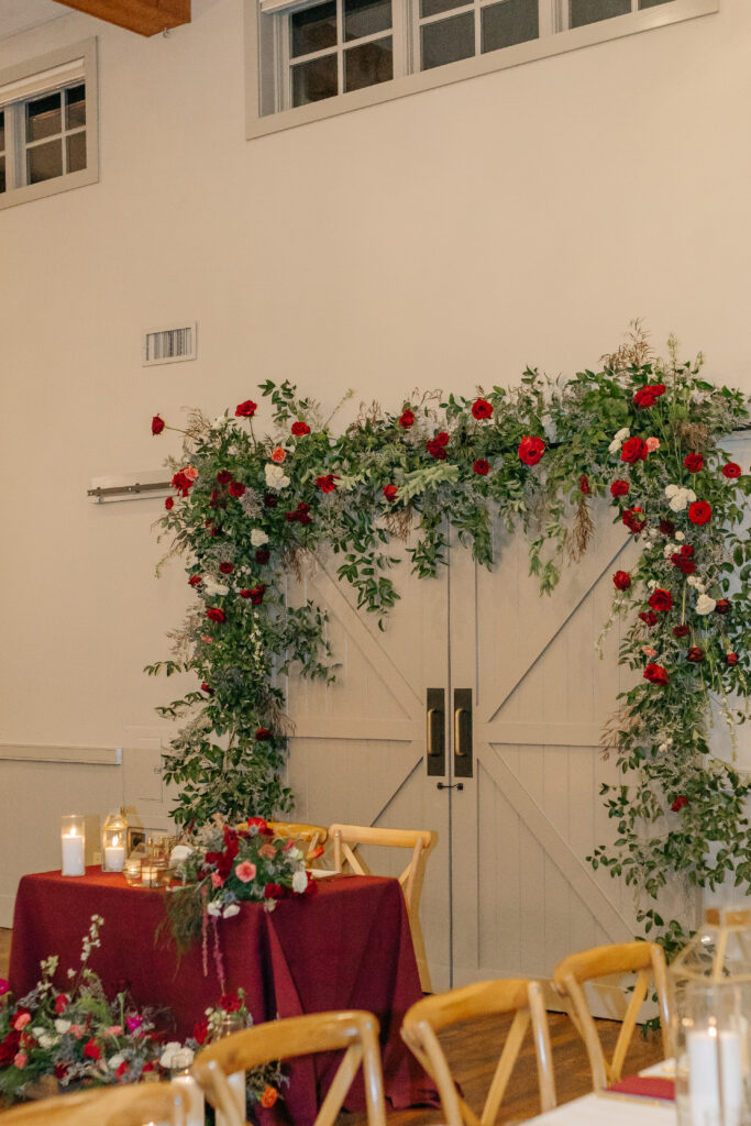 Winter floral design with red Gerbera daisies and blue thistle at Virginia vineyard wedding