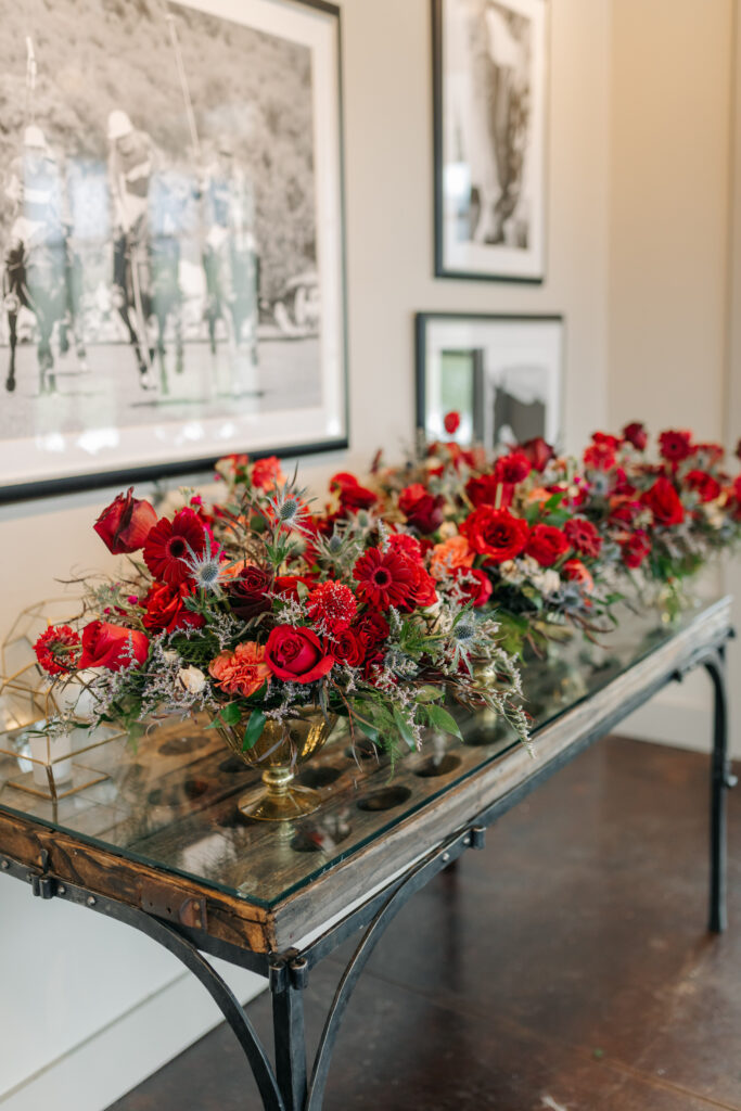Romantic winter wedding flowers with red roses, blue thistle, and greenery at King Family Vineyards