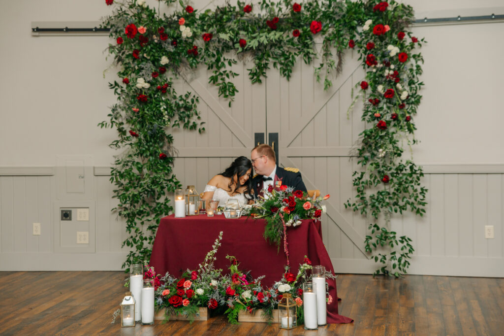 Colorful winter wedding floral installation behind sweetheart table at King Family Vineyards
