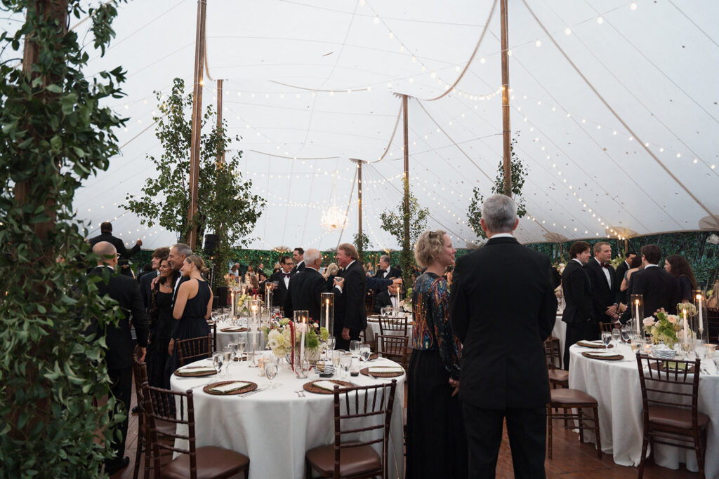 Luxury tented wedding reception with greenery-wrapped tent poles at The Clifton in Charlottesville Virginia