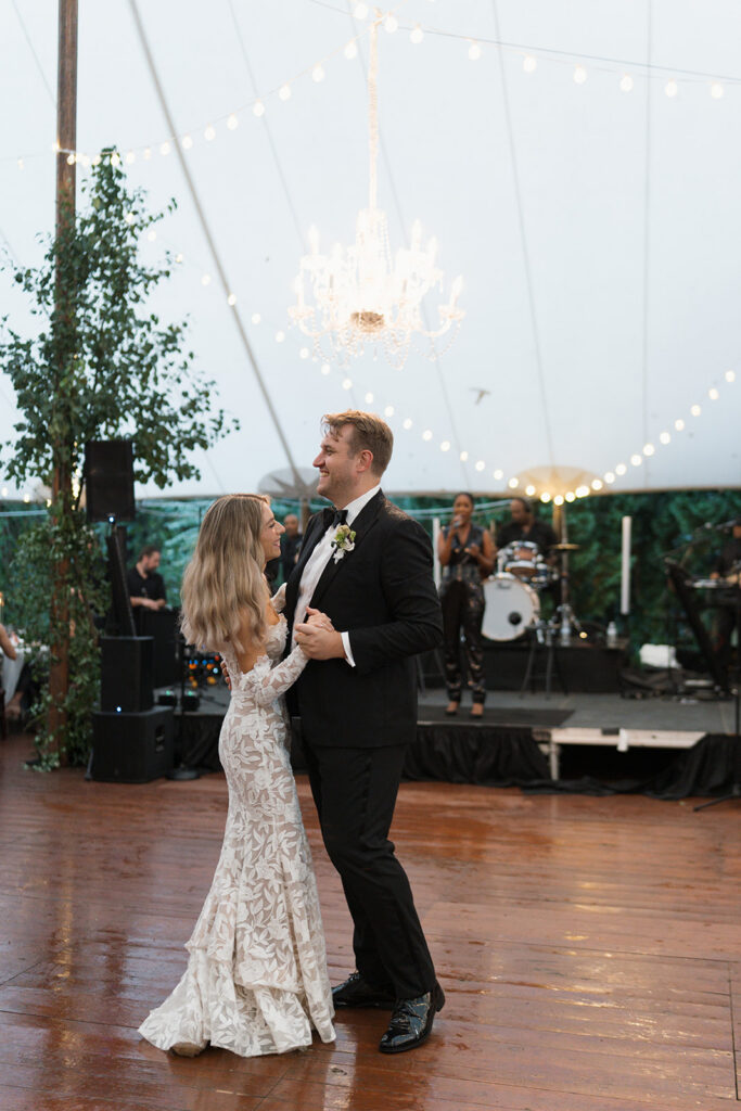 Modern sailcloth tent wedding reception with hydrangeas, calla lilies, dahlias, and architectural greenery